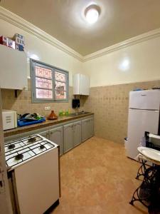 a kitchen with a stove and a white refrigerator at Dar Baddi in Marrakech