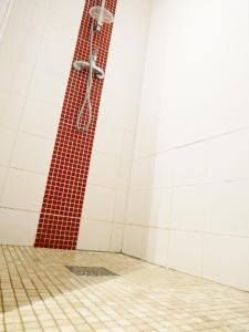 a shower with a red and white tile wall at Right by the Sea • Les Embruns in Martigues