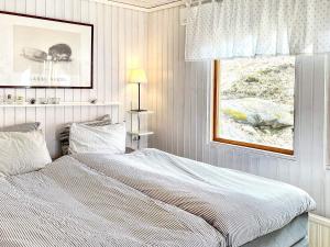 ein weißes Schlafzimmer mit einem Bett und einem Fenster in der Unterkunft Holiday home FAGERHULT IV in Fagerhult