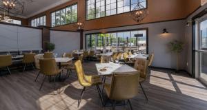 a restaurant with tables and chairs and windows at Best Western Cranbrook Hotel in Cranbrook