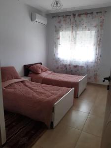 um quarto com 2 camas e uma janela em Appartement S2 Palm Lake Folla - Monastir em Monastir