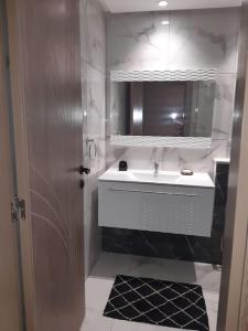 uma casa de banho com um lavatório branco e um espelho. em Appartement S2 Palm Lake Folla - Monastir em Monastir