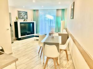 a living room with a table and chairs and a television at Apartamenty u Lucyny i Lecha in Łukęcin