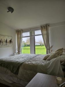 a bedroom with a large bed and a large window at Remarkable 1-Bed Cabin in Dunmow in Great Dunmow