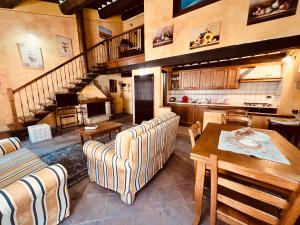 a living room with couches and a table and a staircase at Montepulciano For You in Montepulciano