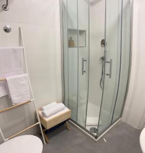 a bathroom with a glass shower with a stool at Casa Artesano, appartamento San Michele in Trapani