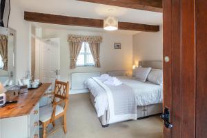 a bedroom with a bed and a desk and a desk at East Hook Farmhouse in Haverfordwest