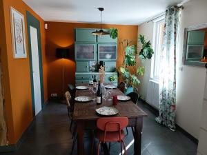 een eetkamer met een houten tafel en rode stoelen bij Gite Jeanne et Léon in Rigny-Ussé
