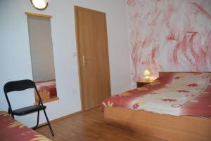 - une chambre avec un lit et une chaise dans l'établissement Ferienwohnung für vier Personen mit Balkon - b58114, à Sukošan