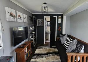 a living room with a couch and a tv at Cloud 9 Estate - Chalet in Knysna