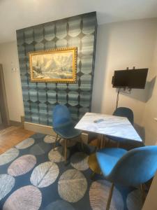 Habitación con mesa, sillas y una pintura en Quiet cosy 1 bedroom apartment Carrington F1 en Nottingham