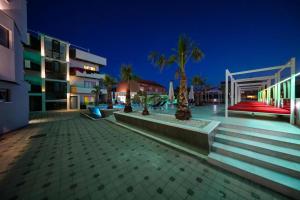 a night view of a building with palm trees and stairs at Boutique Apartments Blitz 1 in Bibinje