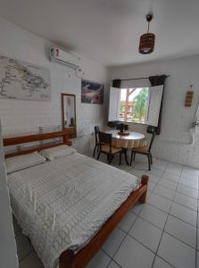 バヘイリーニャスにあるChalé em Porto dos Lençóis Residenceのベッドルーム(ベッド1台、テーブル付)