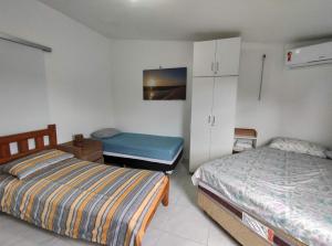 バヘイリーニャスにあるChalé em Porto dos Lençóis Residenceのベッドルーム1室(ベッド2台、キャビネット、ベッド1台付)