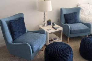 two blue chairs and a table in a room at 314S Nautical Beach Suite - 2 Beds!, Pools, Jacuzzi, Beach, Shops & Dog Friendly in Boynton Beach