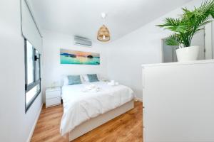 a white bedroom with a bed and a window at Casa Juana Isabela-Villas Gardenia Costa Teguise in Costa Teguise