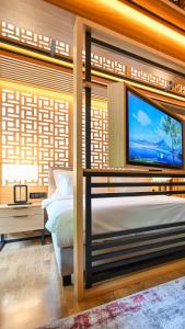 a bedroom with a bed and a tv on a wall at Hanami Design Hotel in Belgrade