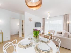 uma sala de estar branca com uma mesa e cadeiras brancas em POLANKI AQUA em Kolobrzeg