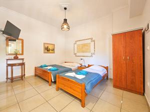 1 Schlafzimmer mit 2 Betten, einem Schreibtisch und einem TV in der Unterkunft Hotel Exarhos in Paralia Katerinis