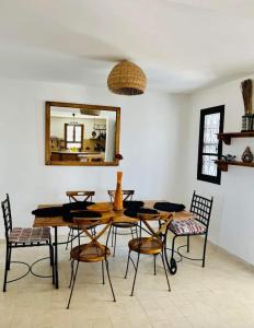 a dining room with a table and chairs and a mirror at Dar Cristina in Houmt Souk