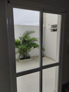 a sliding glass door with a potted plant behind it at Los naranjos in Reconquista