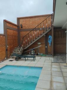 a swimming pool in front of a building with a staircase at Los naranjos in Reconquista