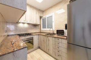 a kitchen with wooden cabinets and a refrigerator at Mar & Cunit in Cunit
