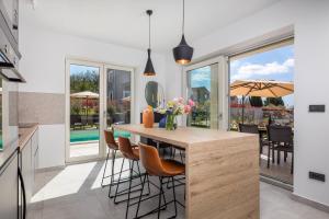 a kitchen with a large island with chairs and a table at Villa Lente in Muntrilj