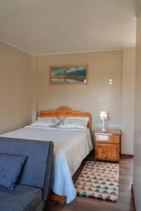 1 dormitorio con 1 cama y 1 sofá en Casa Alojamiento Tocllaraju, en Tarica