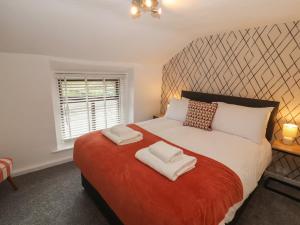 a bedroom with a large bed with two towels on it at Quarter Deck in Ulverston