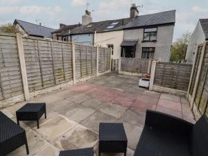 a patio with benches and a fence in front of a house at Quarter Deck in Ulverston