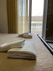 Potamós的住宿－Potamos Riviera House，两条毛巾,放在床边,窗户