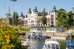 un gran edificio con barcos atracados en un puerto en Small Seaside Cottage, en Saltsjöbaden