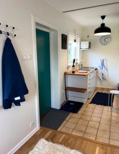 una cocina con una puerta que da a una cocina con encimera en Small Seaside Cottage, en Saltsjöbaden
