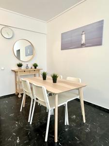 comedor con mesa de madera y sillas blancas en Apartment in the heart of glyfada en Atenas