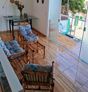 een woonkamer met stoelen en een tafel en een glazen deur bij Pousada Caminho do Mar in Paraty