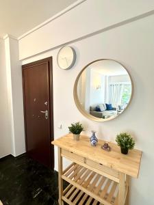 Habitación con espejo y mesa de madera. en Apartment in the heart of glyfada en Atenas