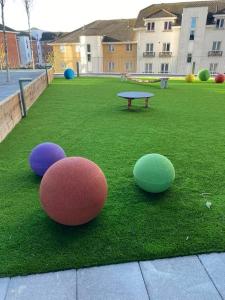 three balls sitting on the grass in a park at Immaculate 3-Bed Apartment Homes in London in London