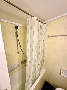 baño con cortina de ducha y bañera en Apartment in the heart of glyfada en Atenas