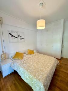 1 dormitorio con 1 cama y luz colgante en Apartment in the heart of glyfada en Atenas