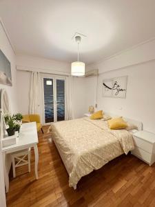Habitación blanca con cama y escritorio en Apartment in the heart of glyfada en Atenas