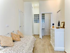 Habitación blanca con cama y baño. en Un espacio diferente en Triana., en Sevilla