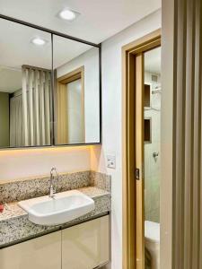 uma casa de banho com um lavatório e um espelho em (903) Studio Belíssimo - Holandeses em São Luís