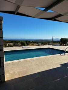 a swimming pool under a roof with a view at Villa Elaia in Sitia