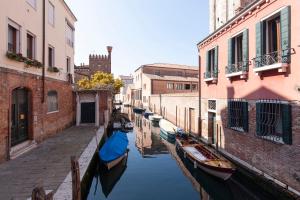 a group of boats in a canal between buildings at Santa Margherita Guest House in Venice
