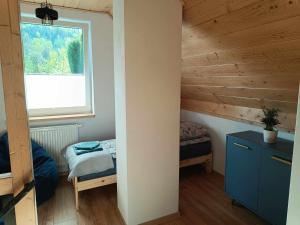 um pequeno quarto com uma cama e uma janela em Biały Domek em Wisła