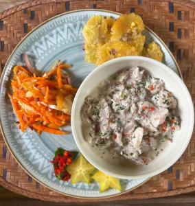 un plato de comida con un tazón de sopa y verduras en luzzul, en Nuquí