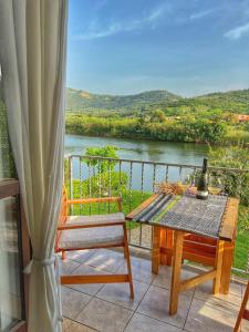 een balkon met een tafel en stoelen en uitzicht op een rivier bij Bosa Apartments "House on the River" in Bosa