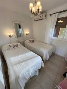 1 dormitorio con 2 camas y lámpara de araña en Espectacular departamento con vista al mar en Cariló