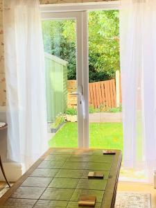 Cette chambre comprend une table et une porte coulissante en verre. dans l'établissement Crosby lovely refurbished flat, direct garden access; Wifi, à Crosby